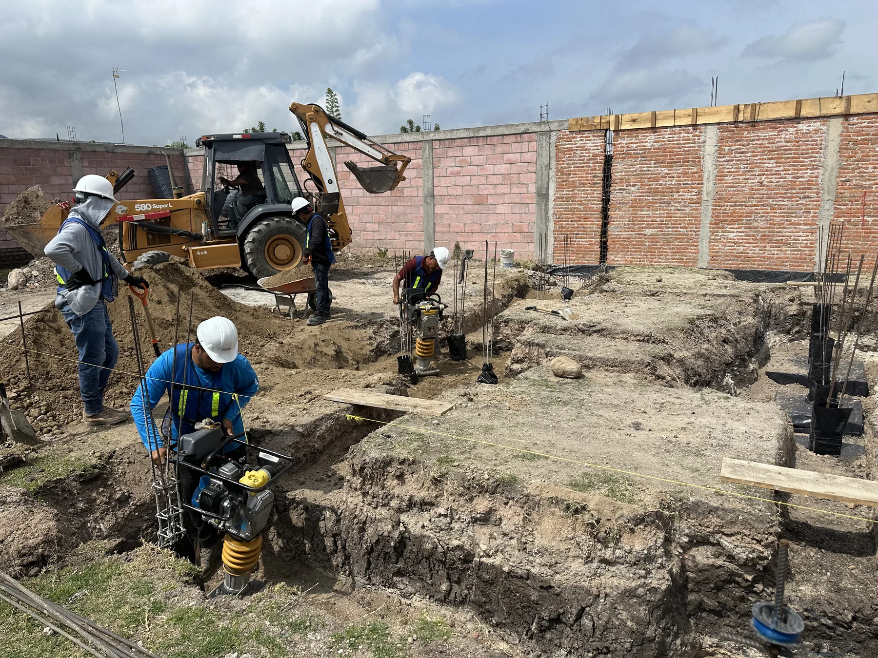 Cuadrilla de SOGRUB compactando cepas de cimentación en obra en Querétaro